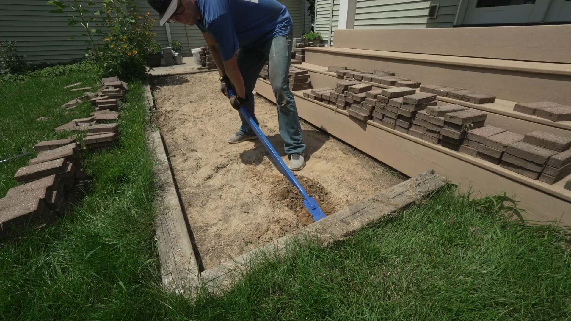 man using pry bar to pry loose railroad ties